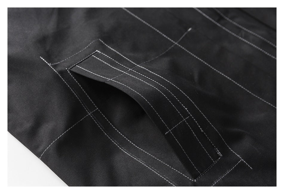 Close-up of a black garment pocket opening with layered white contrast stitching.