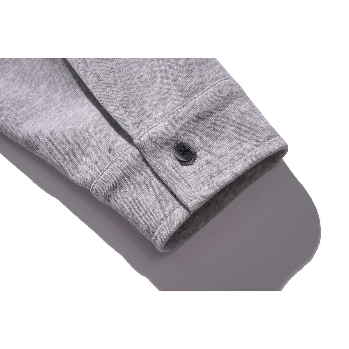 Close-up of a gray sleeve cuff with a dark button.