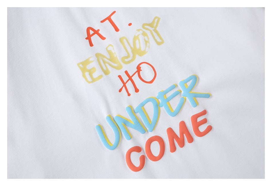 Close-up of colorful raised English lettering printed on a white T-shirt.