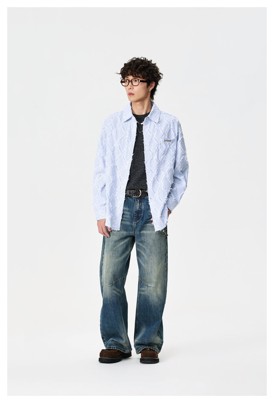 Full-length model wearing a light blue patterned shirt, dark tee, and loose blue jeans.