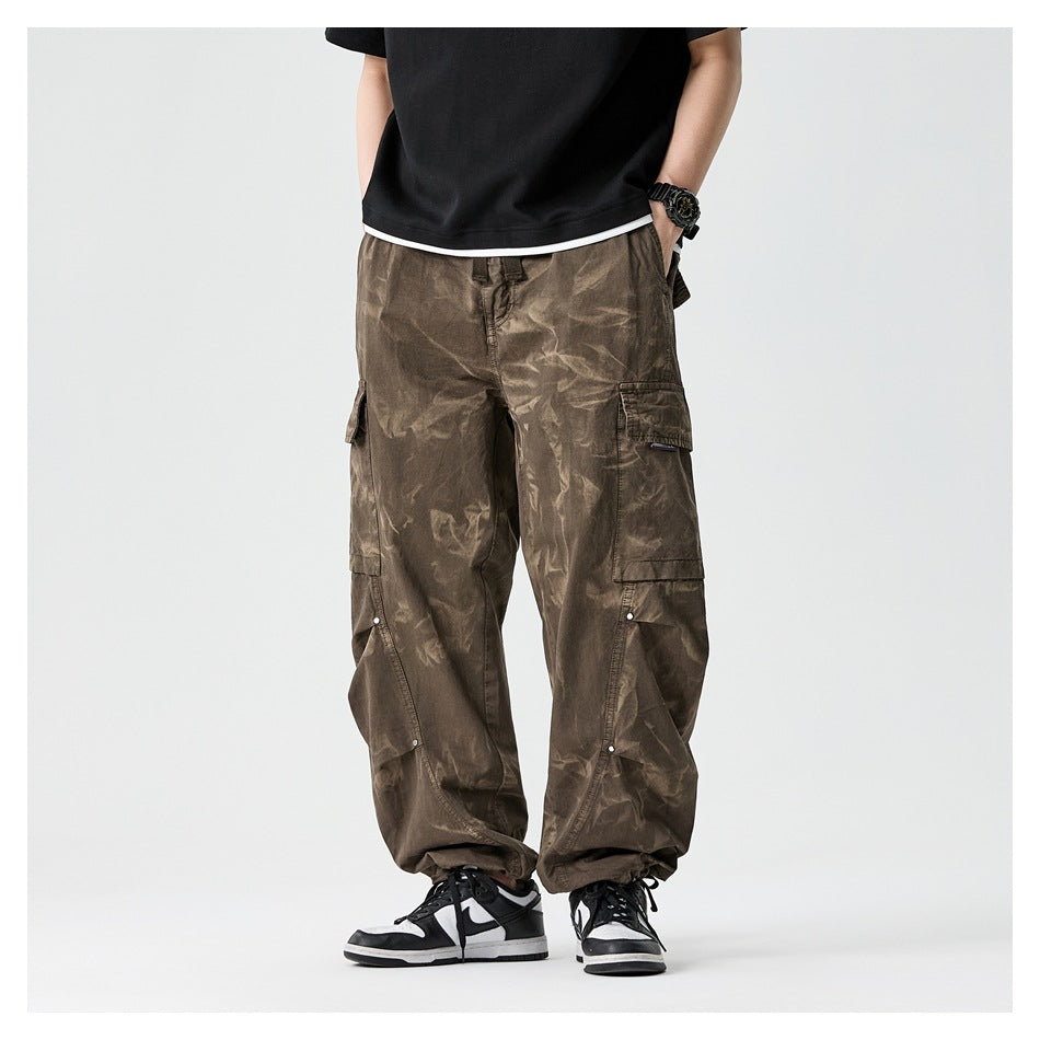 Cropped model standing front-facing in loose olive-brown cargo pants with large flap pockets and gathered ankles.