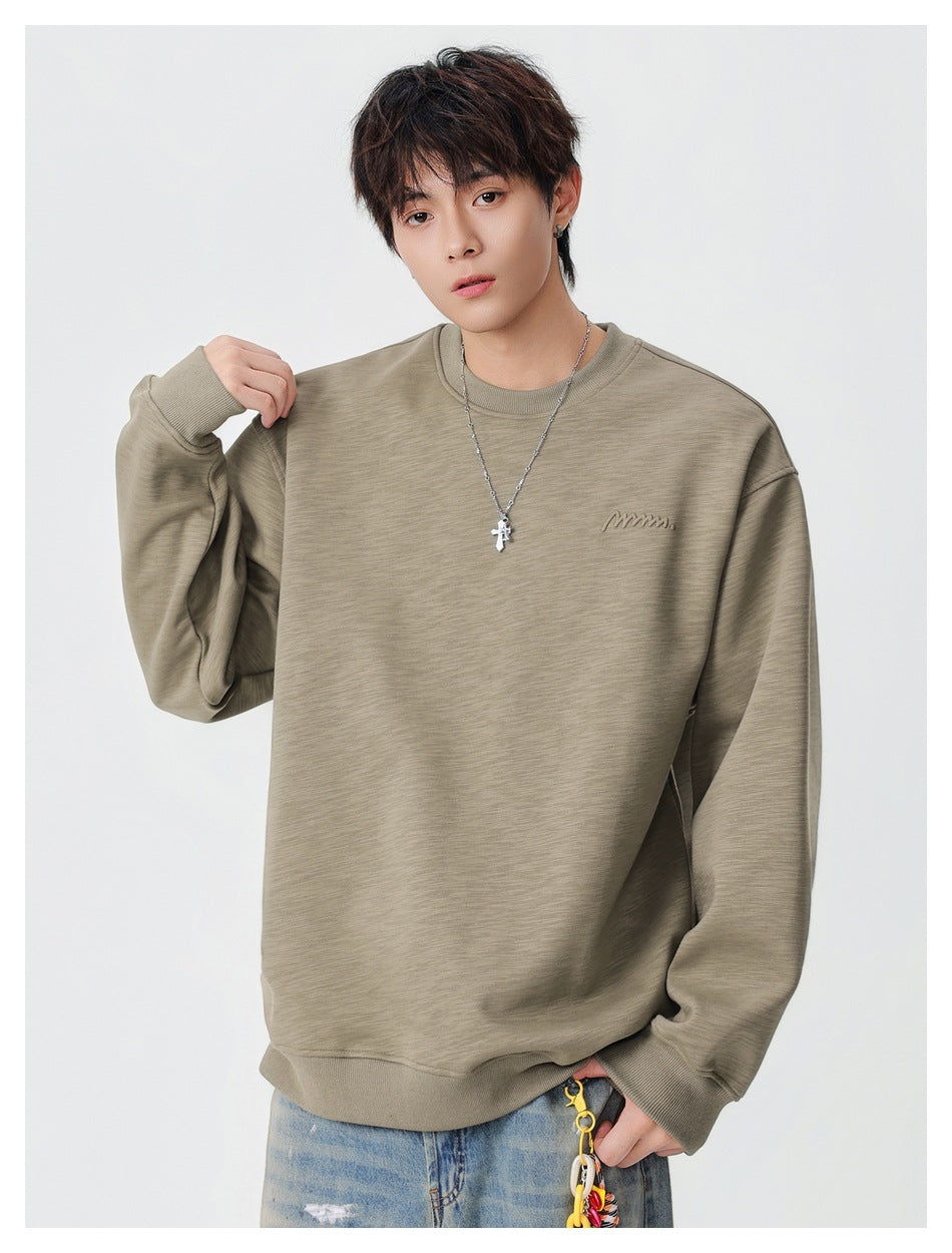 Model wearing a taupe oversized crewneck sweatshirt with ribbed cuffs and hem, shown from the front.