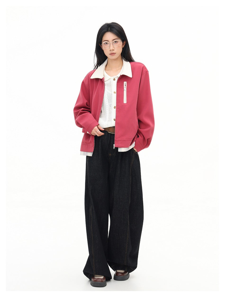 Model wearing a rose-pink jacket with a cream collar and vertical zip pocket, styled with a white knit top and wide black