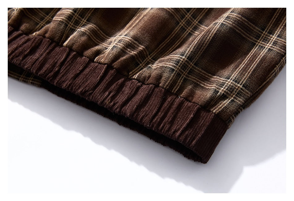 Close-up of the brown plaid garment's gathered dark brown ribbed hem.