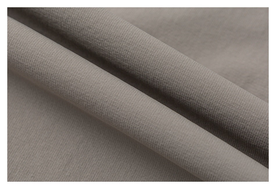 Close-up of taupe fabric folded to show its fine woven texture.