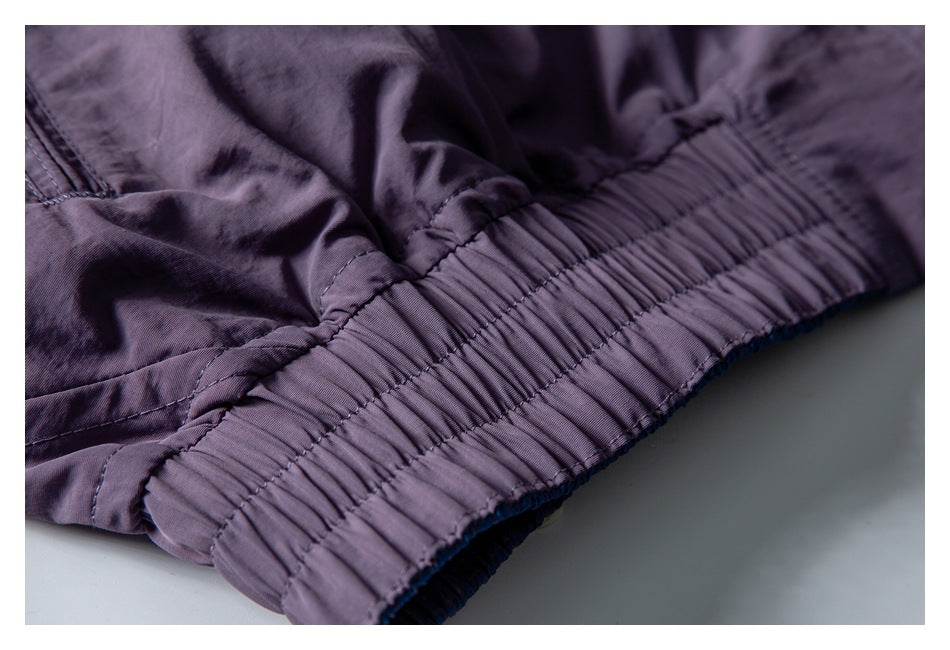 Close-up of a gathered elastic edge and seam on a dark purple garment.