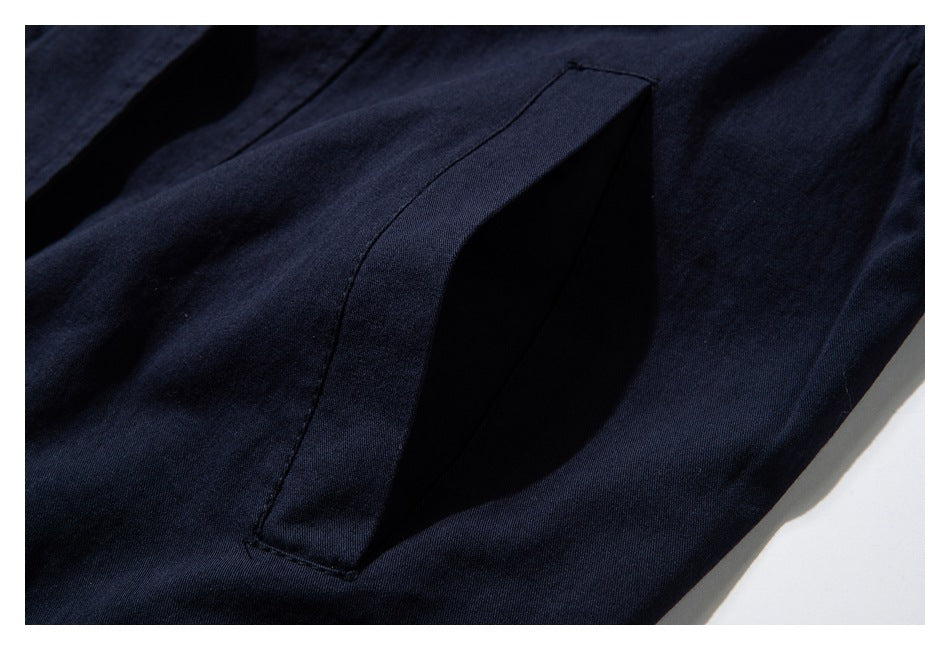 Close-up of a slanted pocket opening on a dark navy garment.