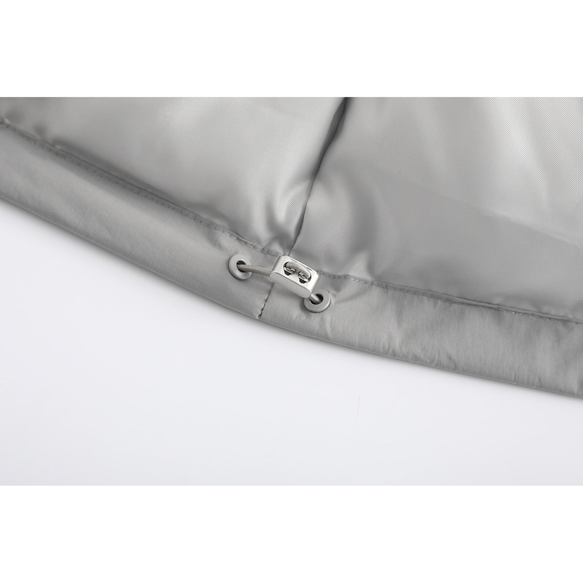 Close-up of the light gray jacket hem with an adjustable drawcord and toggle.