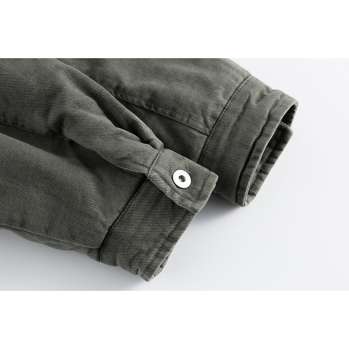 Close-up of the charcoal gray jacket sleeve cuff and adjustable button tab.