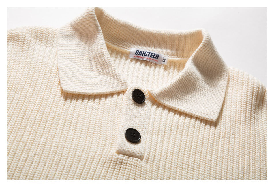 Close-up of an ivory knitted polo sweater showing its wide collar, two dark buttons and neck label.