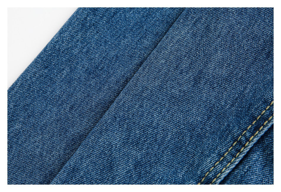 Close-up of blue denim fabric and a diagonal double-stitched seam.