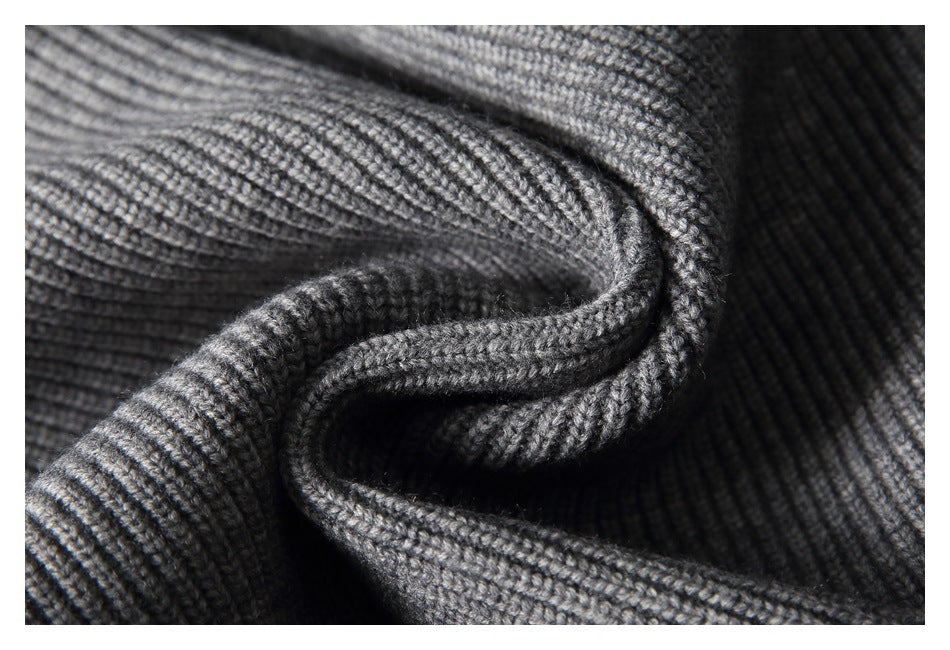Close-up showing the textured rib knit and folds of a gray sweater.
