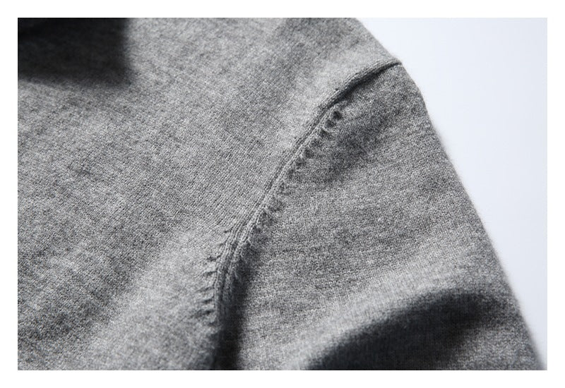 Close-up of a shoulder seam on a heather gray knit sweater.