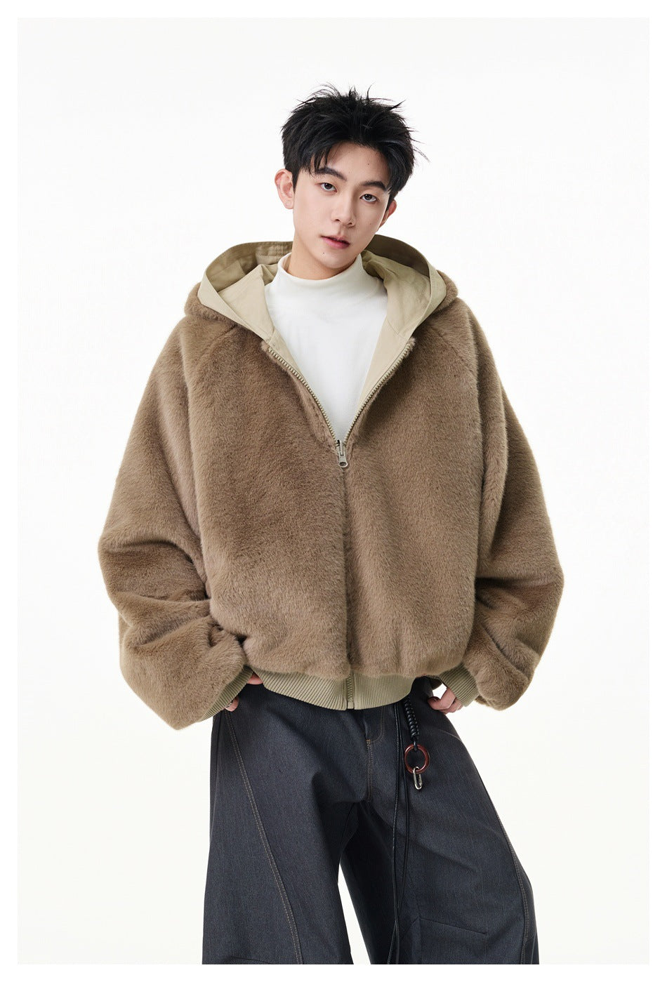 Model wearing a taupe fuzzy hooded zip jacket with ribbed cuffs and hem, paired with dark wide-leg pants.