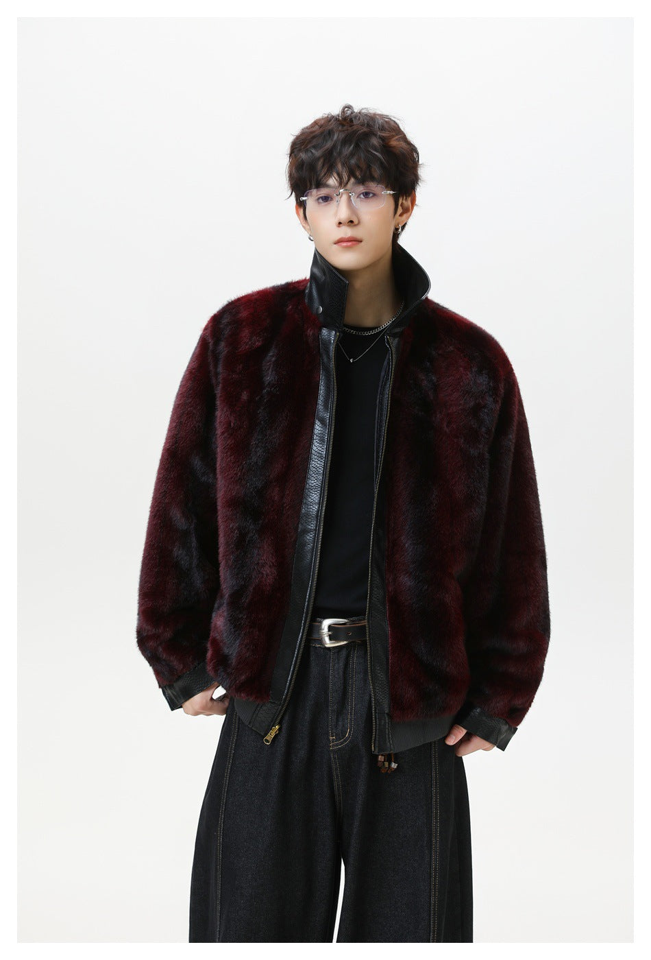 Model wearing a burgundy and black plush-looking jacket with a tall black collar and zip front.
