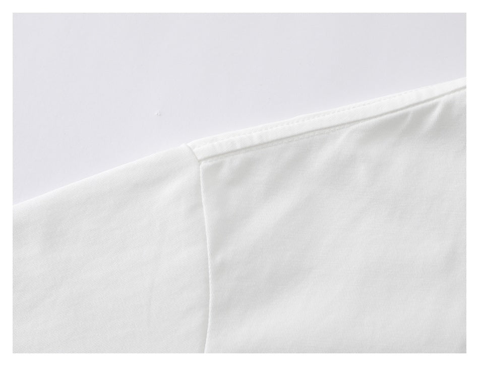 Close-up of the white T-shirt's shoulder seam and stitching.