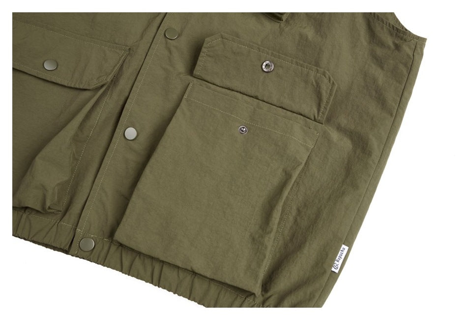 Close-up of the olive jacket's large snap-flap pocket, front snaps and small sewn side label.