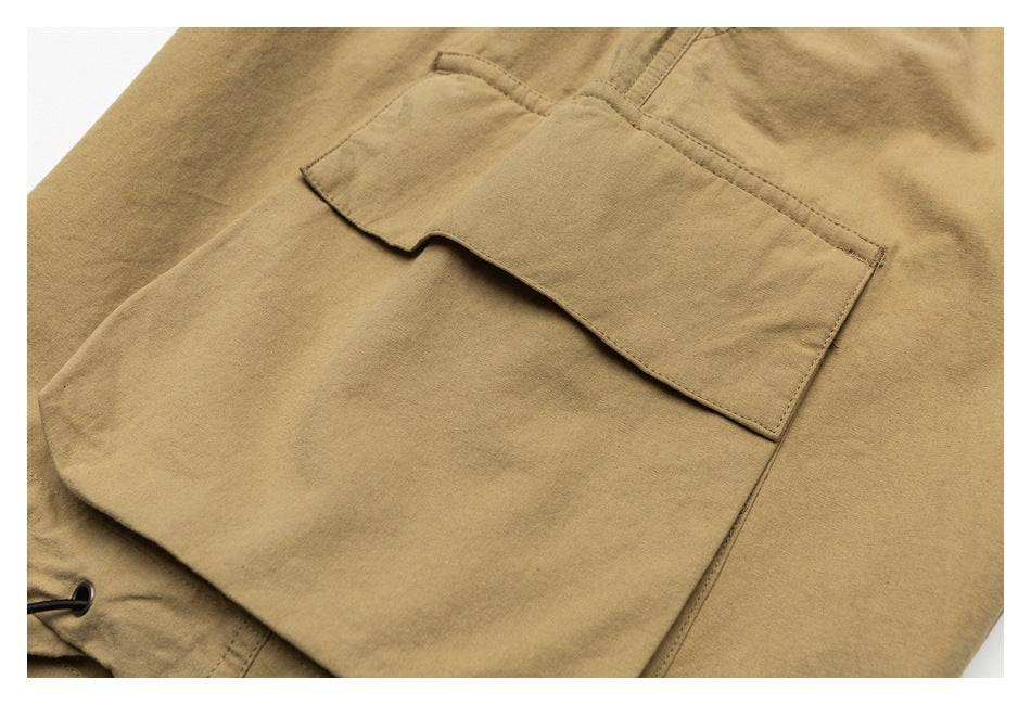 Close-up of a large flap cargo pocket on tan trousers.