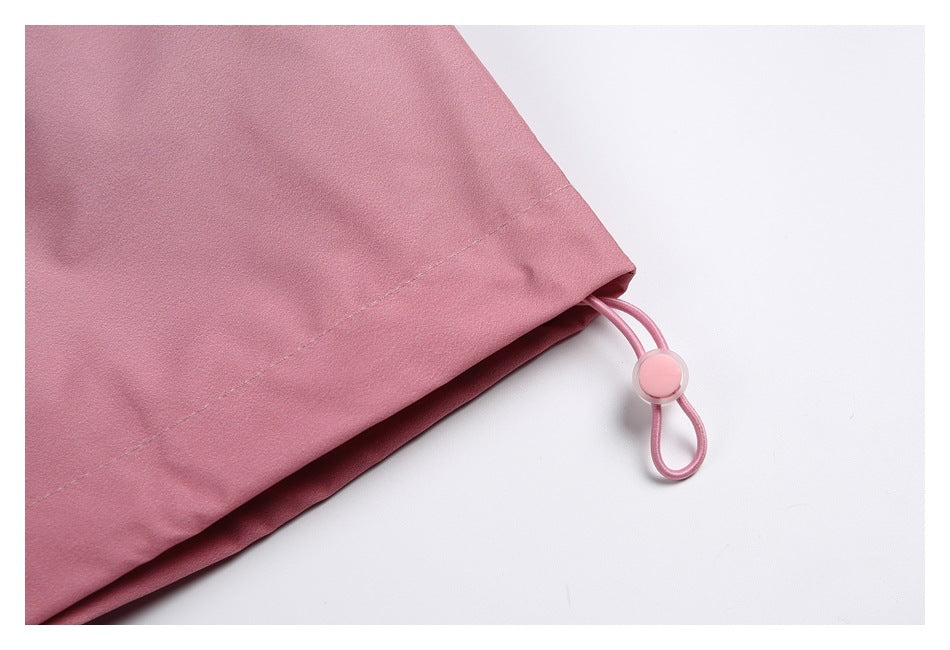 Close-up of a dusty pink garment hem with a looped elastic drawcord and round stopper.