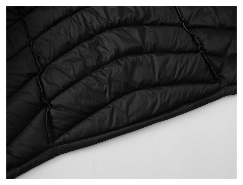 Close-up of black quilted garment showing padded channels and finished edge.