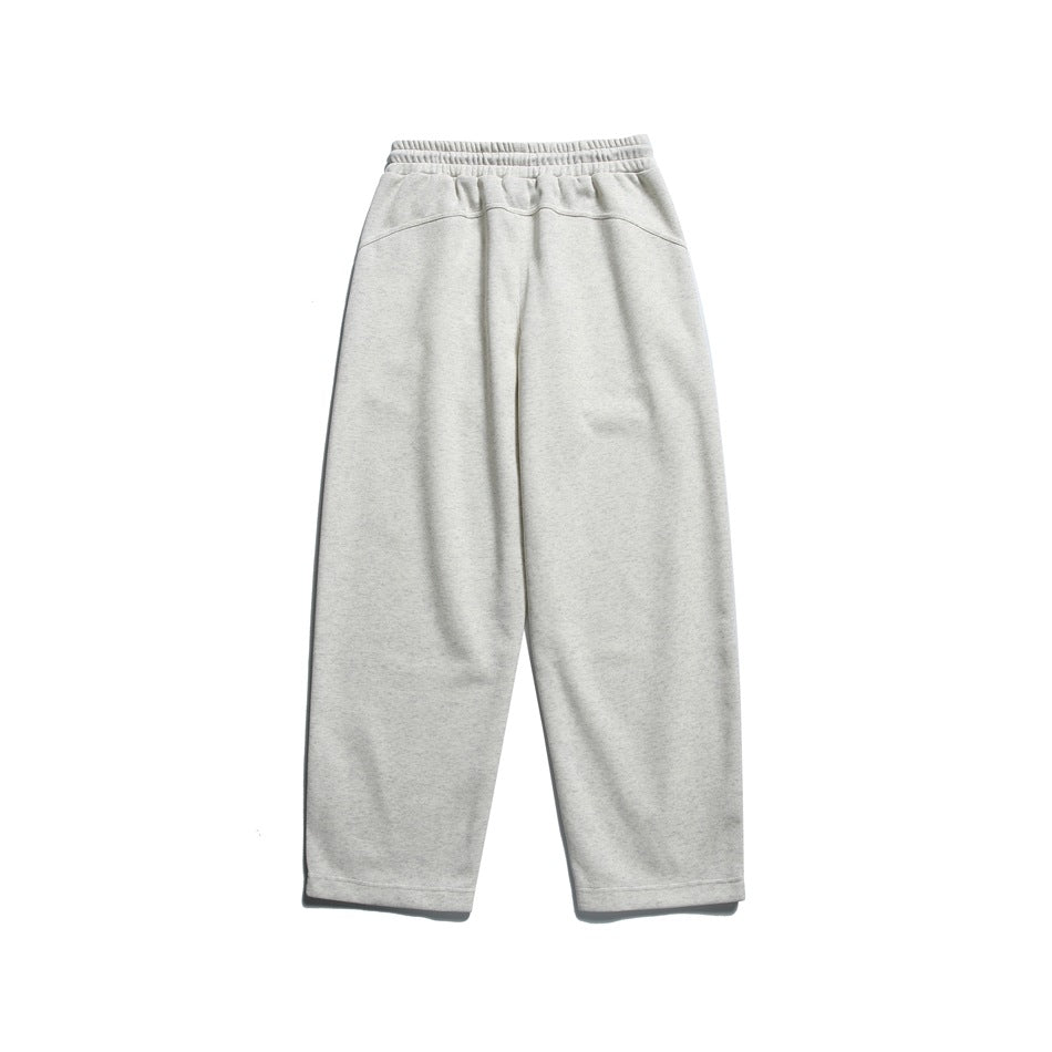 Light heathered off-white sweatpants, laid flat, back view with curved yoke seam and elastic waistband