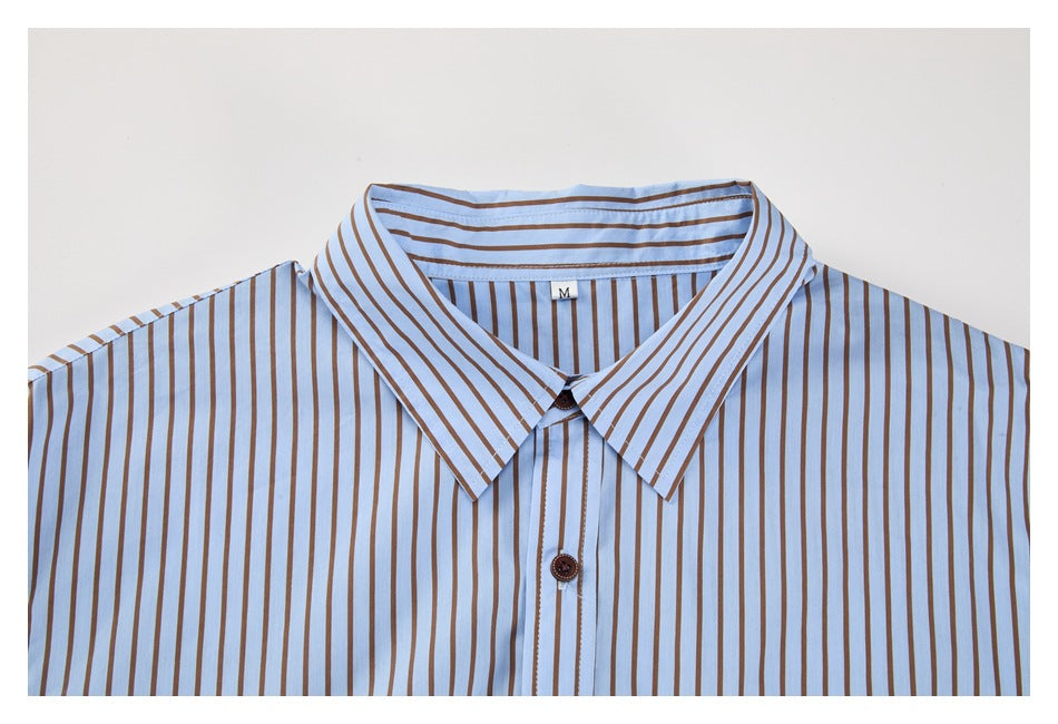 Front view of a light blue button-up shirt with brown vertical stripes, pointed collar, and brown buttons.