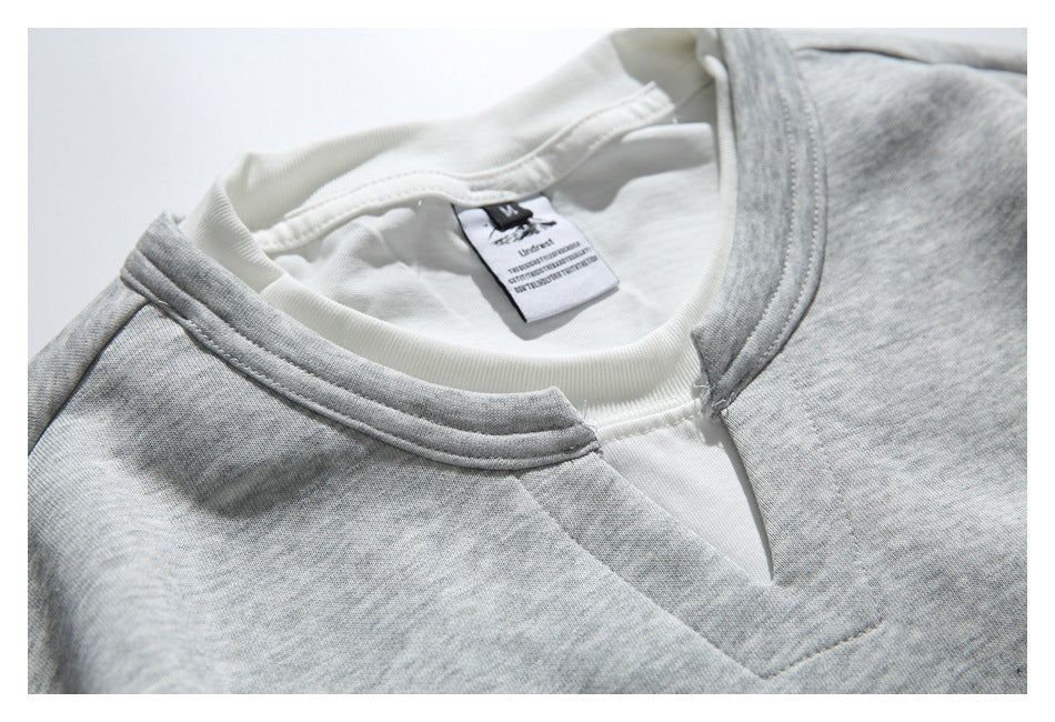 Close-up of the sweatshirt’s white inset split neckline, gray collar, stitching, and inner label.