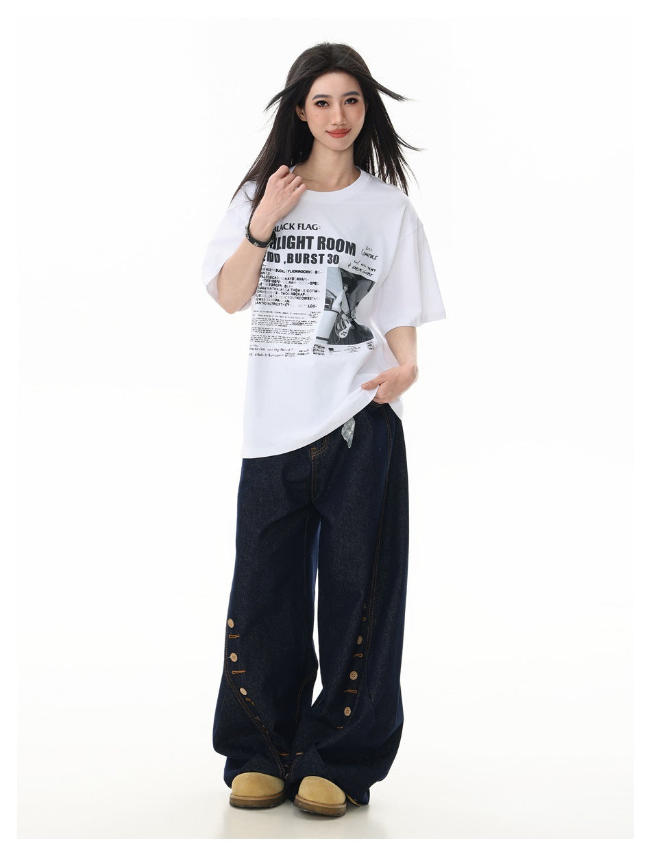 Model wearing the white graphic T-shirt with dark wide-leg jeans and tan boots, standing full length