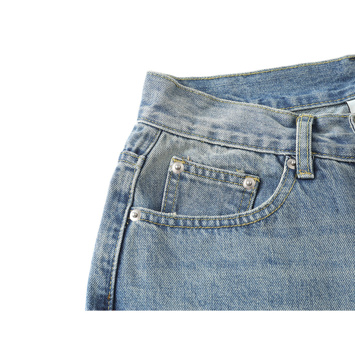 Close-up of the front coin pocket and curved pocket seam on light-wash blue jeans.
