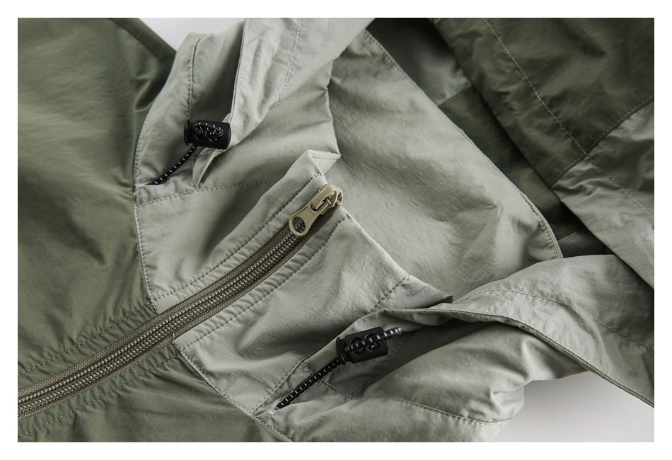 Close-up of the jacket's front zipper, hood drawcord toggles and contrasting sage panels.