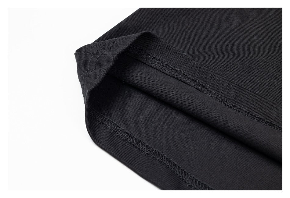 Close-up of the folded hem and overlock stitching on a black garment.
