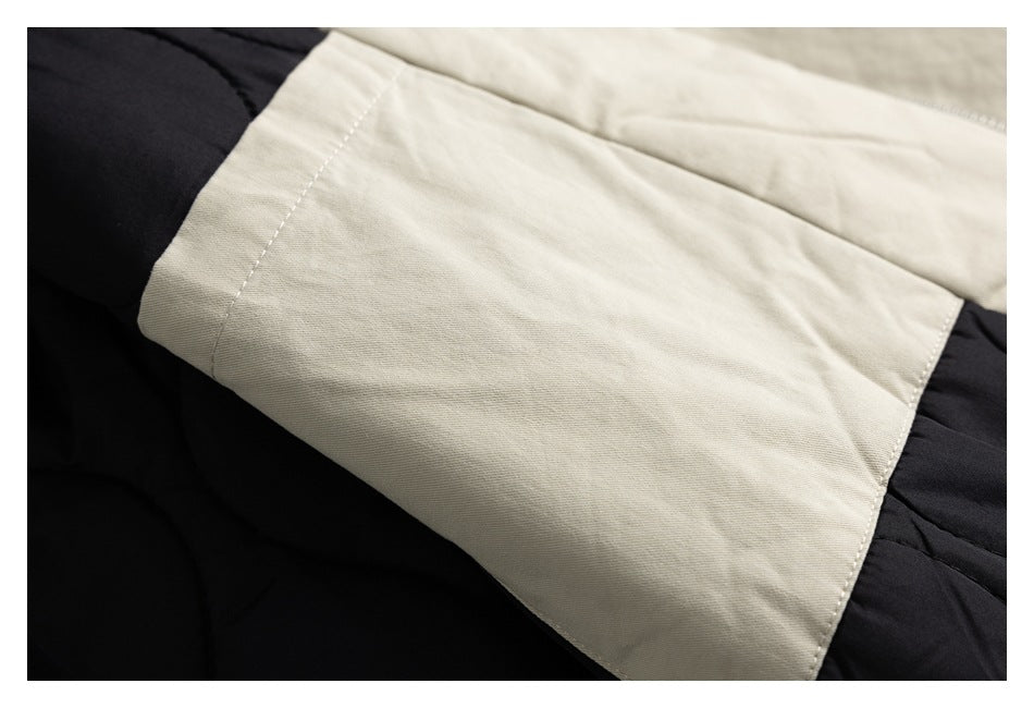 Beige fabric panel laid over black quilted fabric, showing the seam and edge stitching.