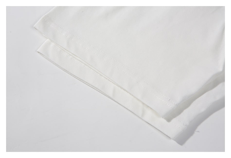 Close-up of a white garment sleeve hem with visible double stitching.