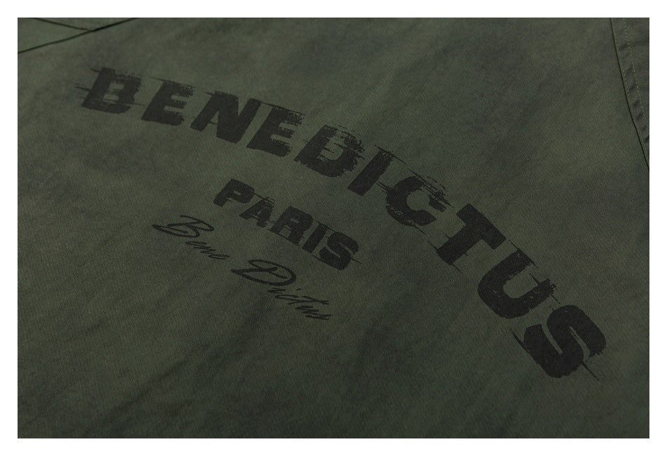 Close-up of the black BENEDICTUS PARIS graphic printed on olive green jacket fabric.