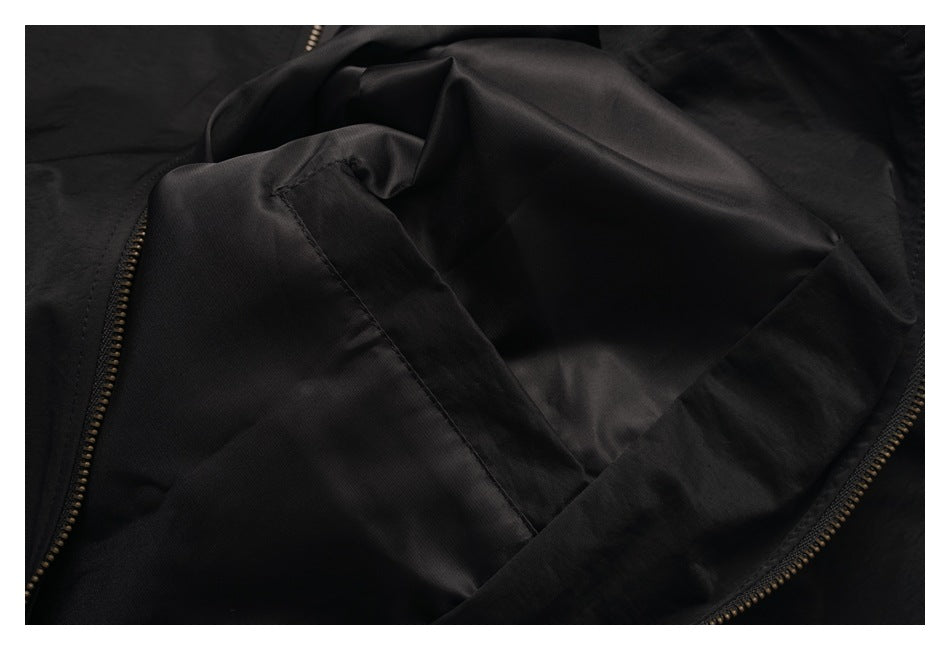Close-up of a black jacket opened to show its dark lining and zipper edges.