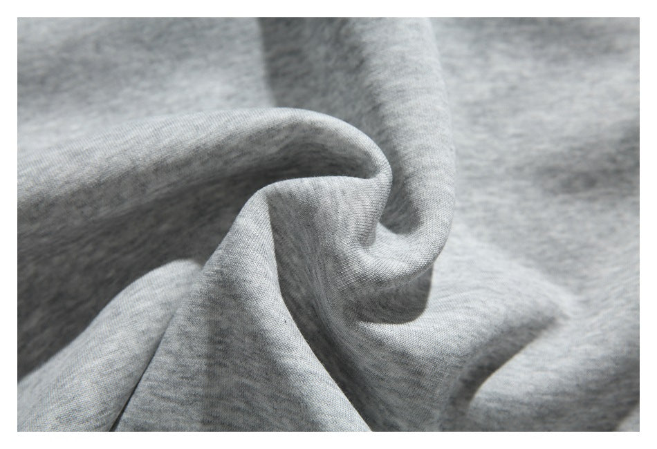 Close-up of softly folded light gray heathered fabric showing its knit texture.