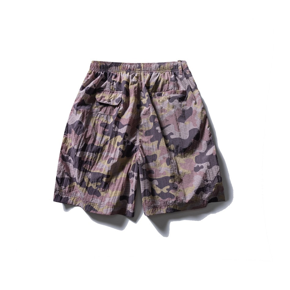 Back view of mauve, gray, and olive camouflage shorts with an elastic waistband and two buttoned pockets.