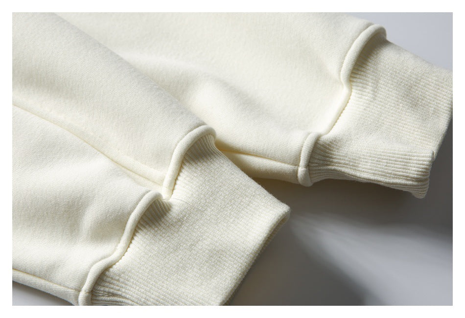 Close-up of cream sweatshirt sleeves with wide ribbed cuffs.