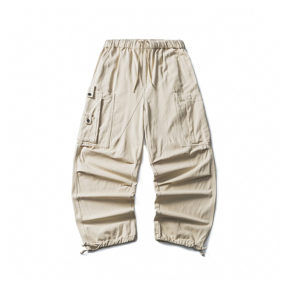 Off-white wide-leg cargo pants flat lay with drawstring waist, snap side pockets and toggle hems