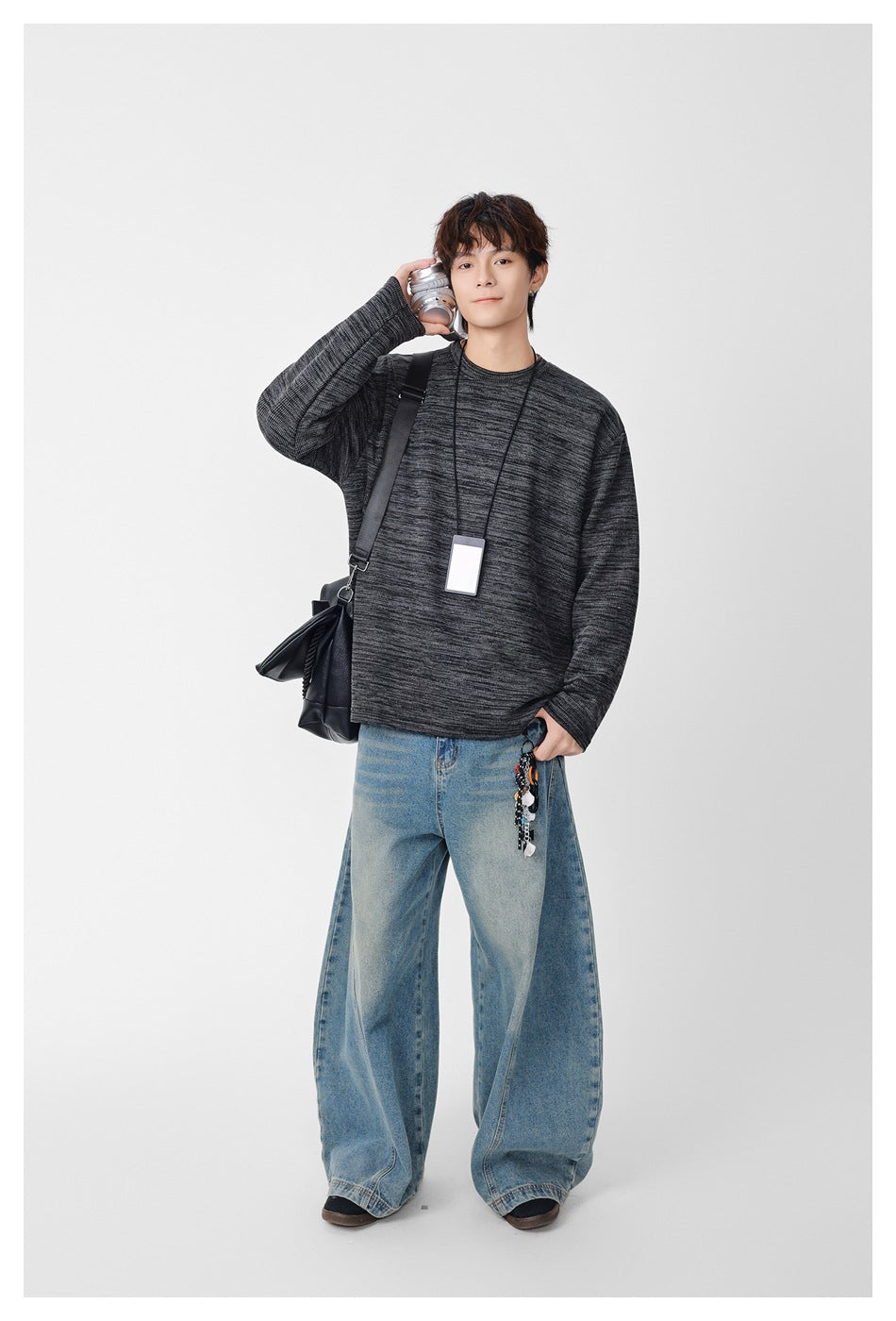 Full-length model wearing a charcoal marled crewneck sweatshirt and wide-leg blue jeans.