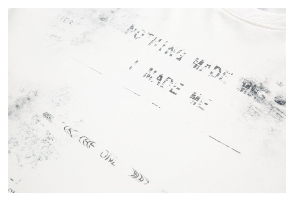 Close-up of a white shirt with a distressed black printed graphic and lettering.
