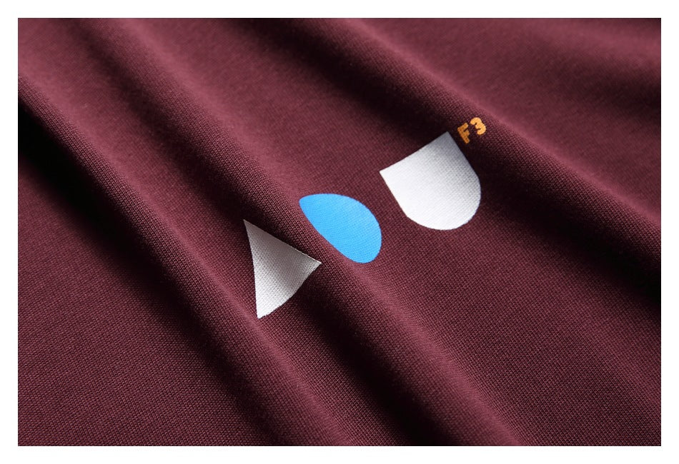 Close-up of the burgundy shirt's white-and-blue geometric print with small yellow F3 lettering.