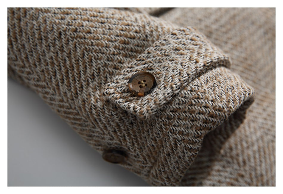 Close-up of a brown button fastening the tweed coat's cuff tab.