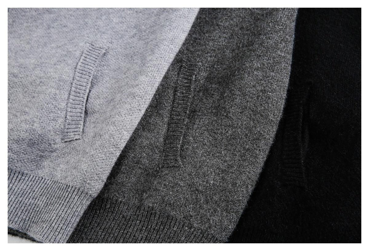 Close-up of light gray, charcoal gray, and black sweaters showing pocket openings and ribbed hem details.