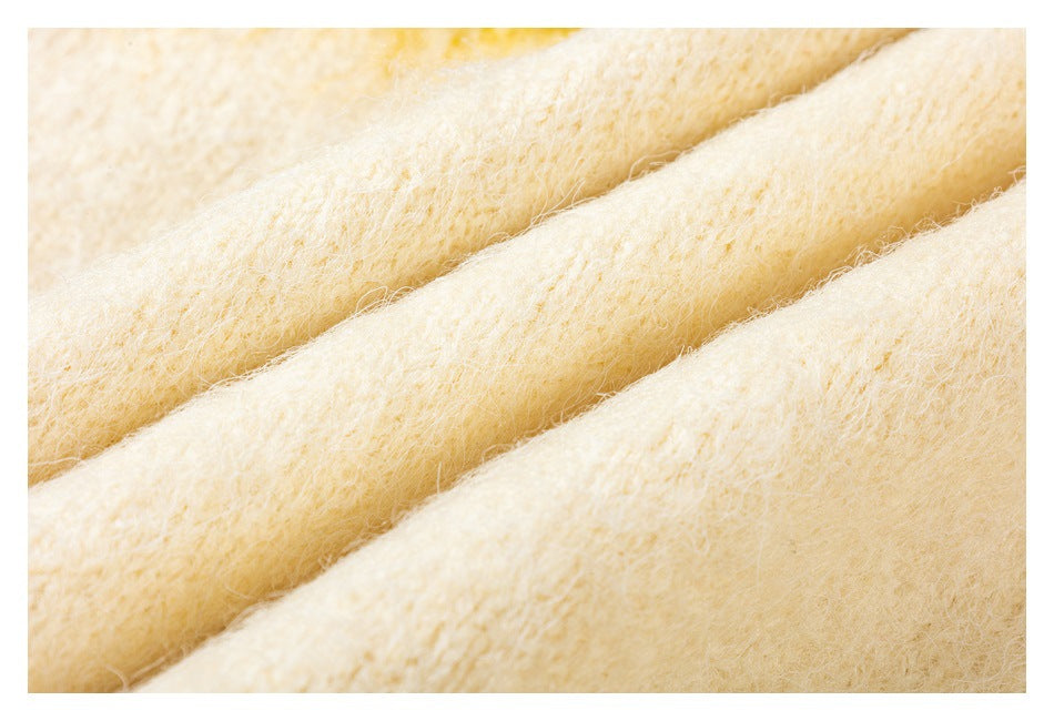 Close-up of soft-looking cream-colored fabric arranged in diagonal folds.