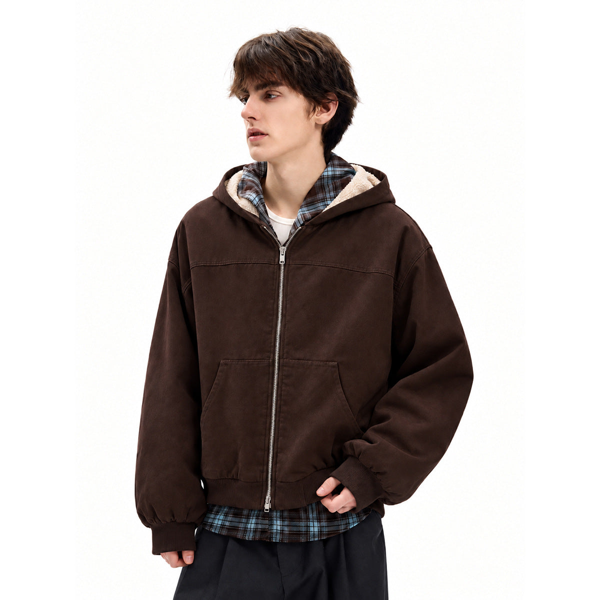 Model wearing a dark brown zip-up hooded jacket with cream lining, ribbed cuffs and hem, and front pockets.