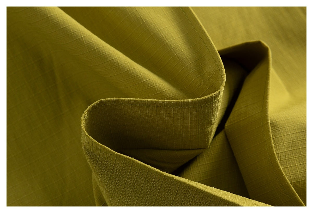 Close-up of folded olive fabric showing its subtle grid texture and finished edge.