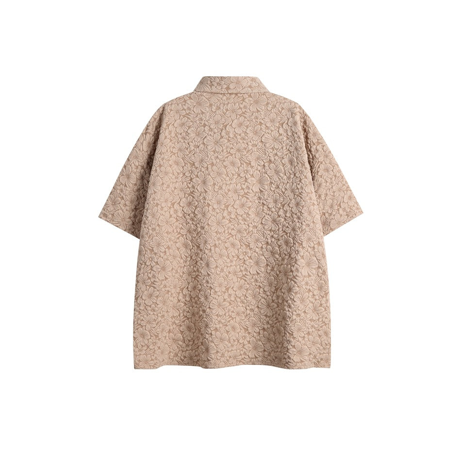 Back view of a taupe short-sleeve collared shirt with an allover floral pattern.