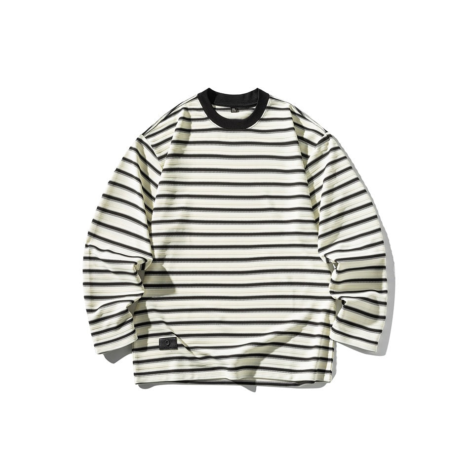 Cream long-sleeve crew-neck top with black horizontal stripes, black collar and small patch at lower hem