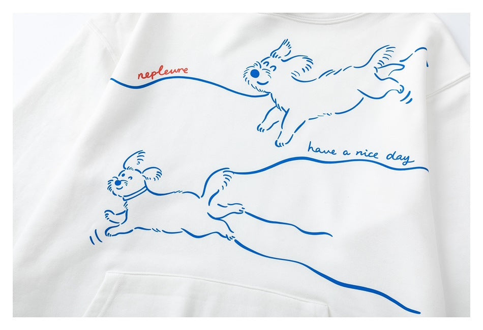 Close view of a white sweatshirt front with blue line drawings of running dogs and the phrase “have a nice day.”